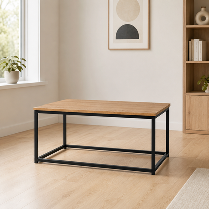 Mesa de centro rectangular con tablero efecto madera clara y estructura de metal negro en un salón cálido