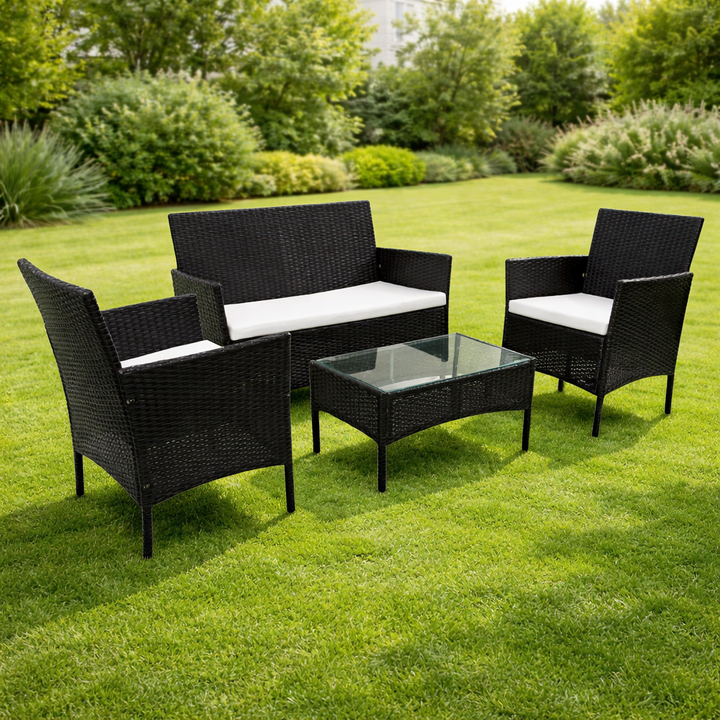 Conjunto de exterior negro con sofá, dos sillones y mesa en un jardín